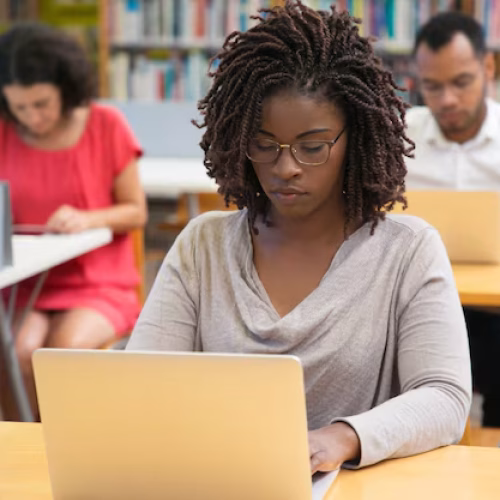 front-view-concentrated-woman-working-with-laptop-library_74855-4250